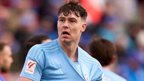 Jorgan Strand Larsen celebrates a goal by pulling at the badge on his light blue Celta Vigo shirt