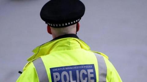 View of the back of a police officer with Greater Manchester Police uniform 