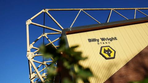 The side of the Molineux stadium, a sign saying Billy Wright stand is visible along with a Wolves logo