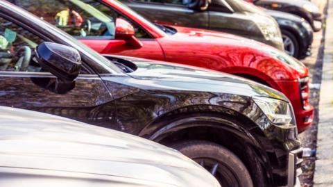 A row of cars parked in a car park