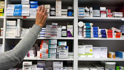 File photo of a pharmacist stocks shelves at a chemist