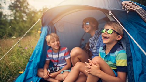 three kids camping and laughing together