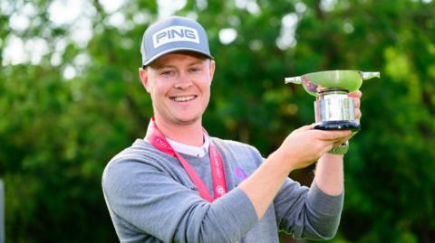 Golfer Brad Smith holding a trophy
