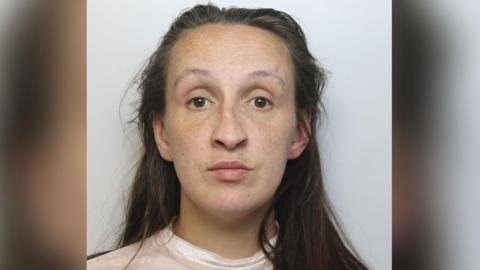 Sinead Doherty looks at the camera in this police photo. She has long brown hair and is wearing a pale pink top.