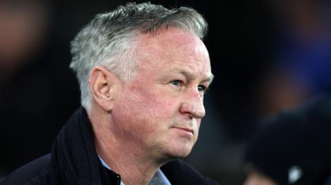 Michael O'Neill wearing a dark coat and light blue smart shirt on the sidelines in Blackburn's defeat by Southampton