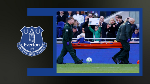 Image of Jarrad Branthwaite being taken off on a stretcher on a blue and black background alongside Everton badge