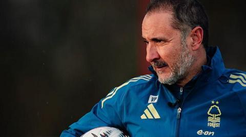 Vitor Pereira looks to the left while holding a ball