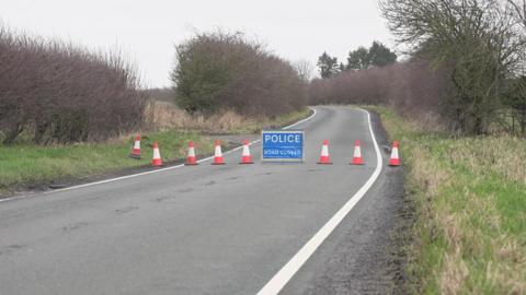 A police road closure sign on Aldborough Road in Withernwick with orange and white traffic cones