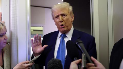 Donald Trump speaks to reporters aboard Air Force One on his return to Washington DC on Wednesday night.