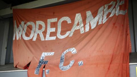 A torn Morecambe FC flag hung up at their Mazuma Stadium home