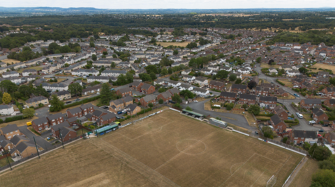 An aerial photograph taken with a drone of a dry football pitch in Llay, Wales.