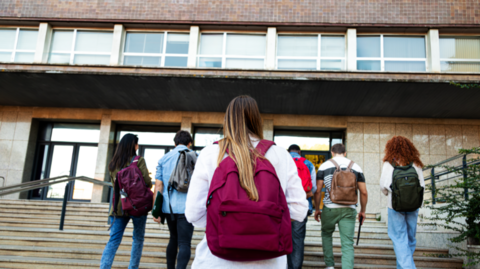 Students walking up some steps towards an university building