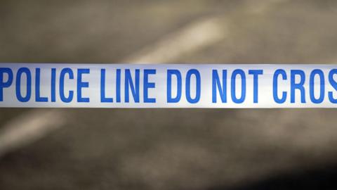 Blue and white police tape with the word Police line do not cross.