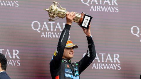 Lando Norris of the United Kingdom and Team McLaren holds up a trophy to celebrate his win at Silverstone on 6 July 2025