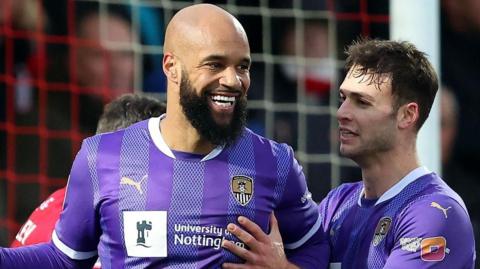 Close up of Notts County forward David McGoldrick celebrating with his team mates after scoring