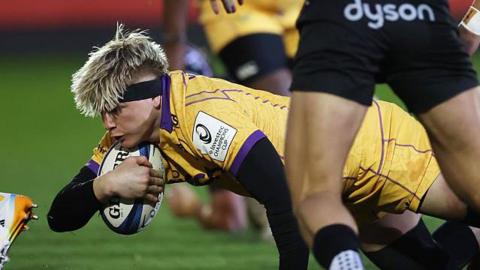 Henry Pollock dives with the ball to score Northampton's first try