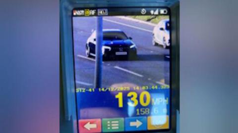 A photo of a screen where police officers have clocked a driver doing 130mph. The car appears to be a dark-coloured Mercedes. 