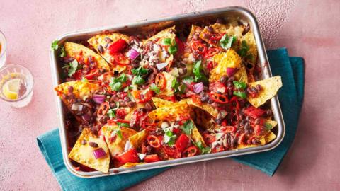 A large tray of loaded black bean nachos.
