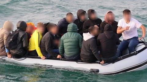A close up of a packed dinghy taken shortly before it was intercepted in the English Channel. The man small boat is carrying 18 adults and one child to the UK from France.