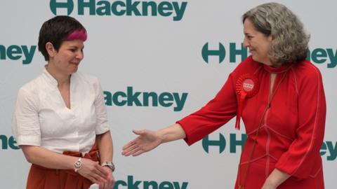 Zoe Garbett and Caroline Woodley shaking hands