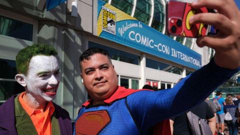 Men dressed as the Joker and Superman take a selfie