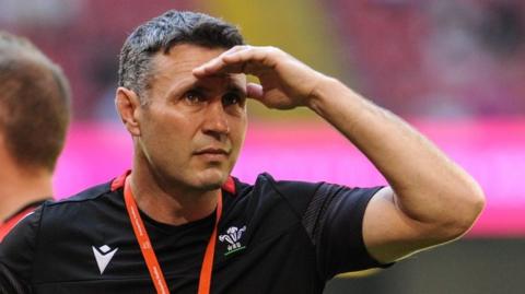 Stephen Jones looks into the distance with his hand shielding his eyes from the sun