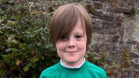 Hudson Paterson pictured wearing a green school jumper. 