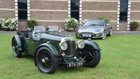 Classic cars pictured on grass outside a building