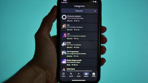 A hand holding a phone showing the categories page of the Character AI app. A list of names of chatbots is shown.