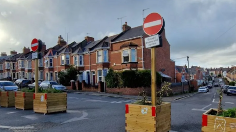 Planters at Heavitree, with houses and road in the background.