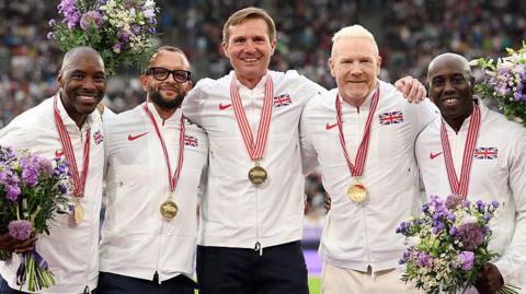 Former athletes of the men's 4x400m relay Great Britain team: Mark Richardson, Jamie Baulch, Roger Black, Iwan Thomas and Mark Hylton, pose for a photo with their gold medals