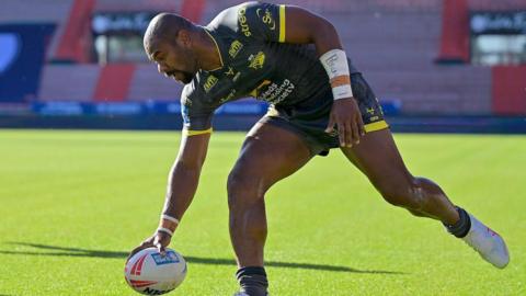 Leeds Rhinos winger Maika Sivo dotting the ball down with his right hand to score a try