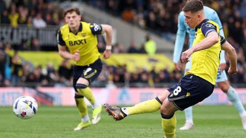 Oxford captain Cameron Brannagan levels from the penalty spot.