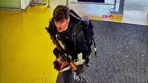 A CCTV image of a man holding a weapon