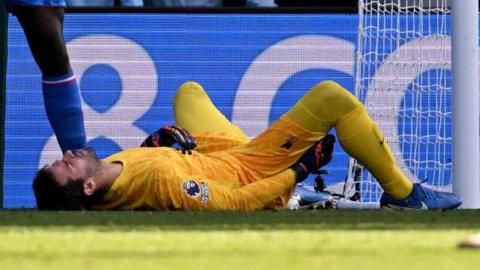 Alisson lies on the pitch after suffering an injury at Crystal Palace