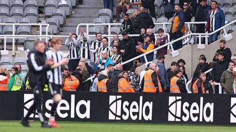 Eddie Howe walking in front of some Newcastle supporters at the end of the Sunderland game