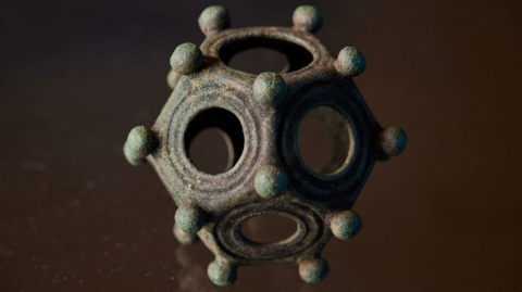 A rare Gallo-Roman dodecahedron - a 12-sided hollow object which stands about 8cm tall and weighs 245g.