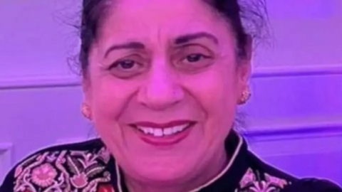 A picture of Pulvinder Dhillon, who has long hair tied back and is wearing gold earrings. She is smiling for the camera.