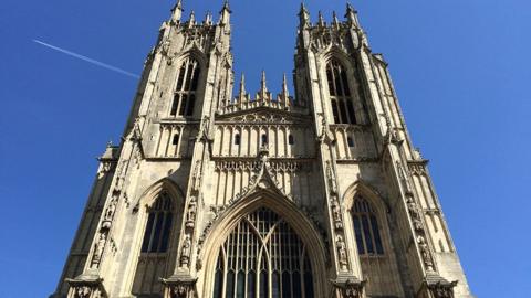 The east end of Beverley Minster showing two towers and the medieval window surrounded by columns with carved figures.