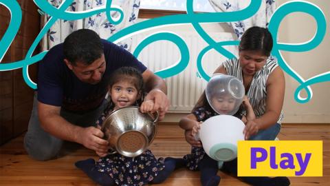 Mother, father and two children playing with mixing bowls together.