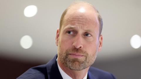 Close up shot of Prince William  in a navy suit 