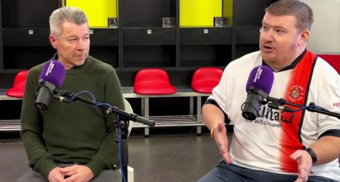 A live streamed preview of Watford v Luton Town filmed inside Watford's dressing room with two men sat in seats