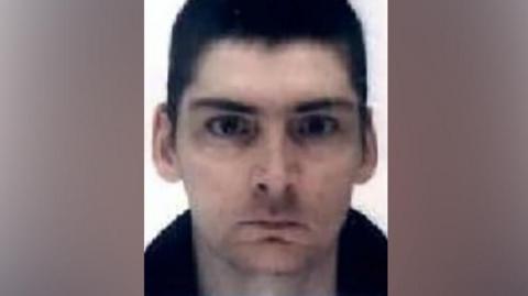 A man with cropped, dark hair looking directly into the camera.