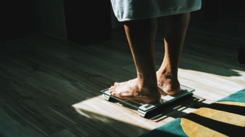 A person standing barefoot on a set a scales