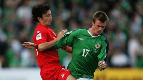 Wales' Simon Davies challenges Northern Ireland's Chris Brunt in 2005