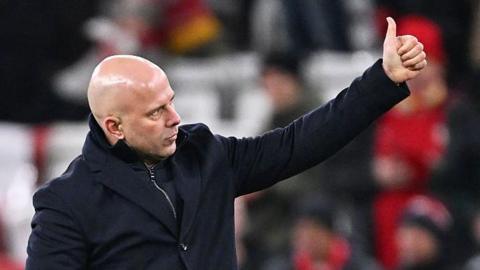 Arne Slot gives a thumbs-up to the crowd at Anfield