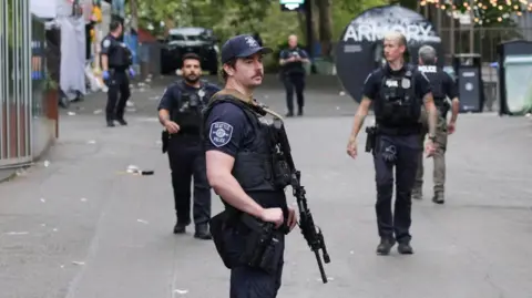 Police officers stand guard at a site after Seattle Police responded to what they described as a shooting with "multiple" victims at Seattle Center,