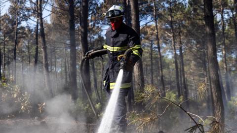A French firefighter crew battles a wildfire spreading in Claouey, southwestern France, 28 July 2026.