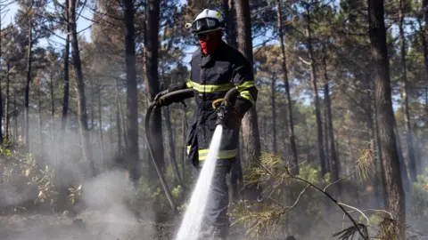 A French firefighter crew battles a wildfire spreading in Claouey, southwestern France, 28 July 2026.