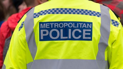 The back of a Metropolitan Police officer's high-vis uniform is pictured.